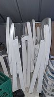 Stack of white plastic folding chairs leaned against wall