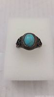 Front view of the antique ring showing the oval turquoise stone set in the metal band.