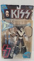 Ace Frehley action figure in black and silver stage costume with makeup in blister pack packaging. Packaging shows wear and has KISS logo and character name.