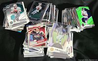 Top-down view of several piles of assorted football cards, showing different card designs and styles, mostly mint or near mint condition.
