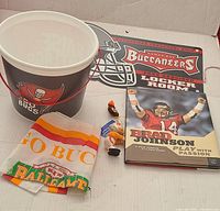 Photo of the Tampa Bay Buccaneers game bucket, Brad Johnson book, rally towel, and two mini player figurines.
