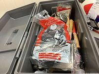 Open plastic tool box showing craft hammers, plastic plugs, and other hand tools inside in original packaging.