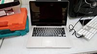 Front view of Apple MacBook Pro Model A1278 laptop showing keyboard, trackpad, and screen (off). No cables visible.