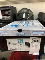 Photo of Skechers shoe box label showing size 12 men's, navy color, Claye model, Relaxed Fit and Memory Foam features, machine washable.