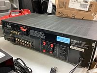 Rear view of the Yamaha RX-V470 receiver showing speaker terminals, RCA inputs and outputs, antenna connections, power cord, and model information sticker.
