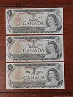 Front side of three consecutive 1973 Canadian one dollar bills showing Queen Elizabeth II portrait and serial numbers BAL2739802, BAL2739803, and BAL2739804.