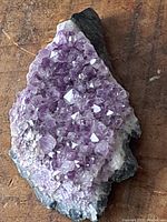 Top view showing the purple amethyst crystals densely clustered on the rock base with natural gray outer edges.