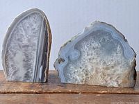 Two cut and polished agate pieces side by side showing intricate internal crystalline patterns and smooth polished surfaces against a white background.