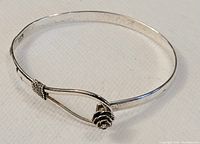Hinged silver bracelet with a small rose flower and wire wrapping detail