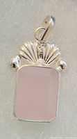 Front view of sterling silver pendant showing rectangular polished rose quartz and decorative fan-shaped silver elements with silver balls on the sides.