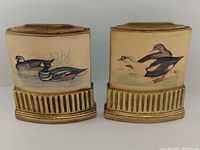 Front view of the pair of vintage Borghese bookends with duck paintings and gilt base.