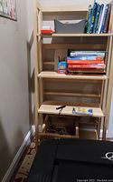 Front view of the collapsible wooden book shelf showing contents and condition.