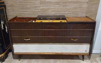 Front view of closed console showing wood veneer panels and white speaker grille