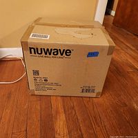 Closed cardboard box with NuWave branding and product info.