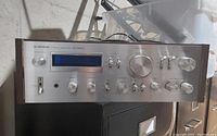 Front full view showing silver faceplate, control knobs, blue display window and wood side panels