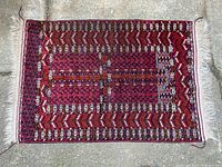 Full view of hand woven rug laid flat on concrete