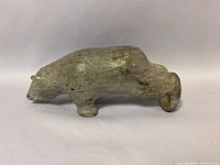 Side angle view of the Inuit soapstone bear carving showing overall shape, texture, and wear.