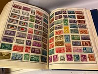 Open album pages showing assorted postage stamps from the United States in various colors and designs.