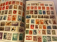 Opened album page showing assorted postage stamps from Argentina including portraits, animals, flowers, and buildings.