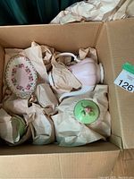 Full view of box with assorted china items wrapped in paper