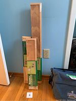 Three Regency Display Ledges in original packaging standing against a wall on a wooden floor.