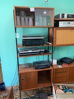 Full height view of two adjacent modular units showing open top shelf with glassware, audio equipment and lower cabinets