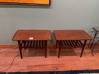 Two mid-century modern wooden accent tables side by side