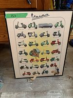 Framed poster showing various Vespa scooter models depicted with colorful illustrations and their years. The frame appears black with a glass front, and the poster is dusty.