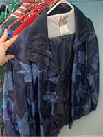 Dark blue floral windbreaker jacket hanging on rack