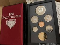 Red folder labeled '1988 Eagle Premier' showing eight coins mounted in black foam insert