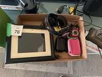 Lot contents including black digital picture frame, black headset, red compact digital camera, two camera cases (black and pink) and other accessories in a cardboard box