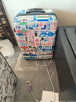 Full view of the front of the suitcase showing colorful Canadian-themed graphics and brand logo.