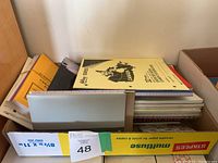 Box of assorted new notebooks, composition books, and sketchbook with Canadian map on cover.