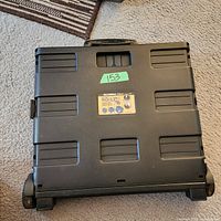 Folded flat bottom view showing wheels and Olympia Pack-N-Roll label