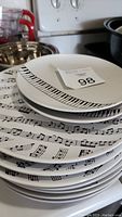 Stack of music-themed plates showing piano keyboard and musical notes designs