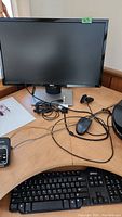 Dell monitor, keyboard and wired mouse on desk, Dell desktop computer visible to side