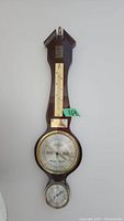 Front view of vintage German wall-mounted weather station showing thermometer, barometer, and hygrometer gauges in a wooden frame.