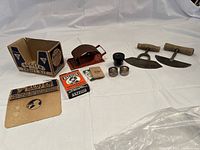 Full lot depiction including two wooden-handled cutting blades, Bugler Thrift Kit box with roller and packaging, and ink wells.