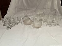 Full set of two covered bowls, one uncovered bowl, eight goblets, and seven small goblets arranged on white background.
