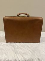 Front view of brown leather briefcase with smooth finish and metal clasp