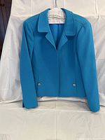 Solid bright blue women's jacket with textured fabric, tailored fit, collar, long sleeves, and silver buttons on pockets.