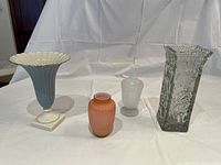 Four vases including blue ribbed Lenox vase, pink ceramic vase, milk glass vase with stopper, heavy clear glass vase