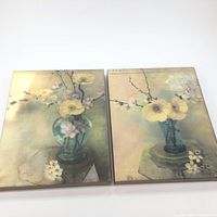 Front view of two floral canvas prints showing yellow and white flowers in blue vases on muted soft backgrounds.