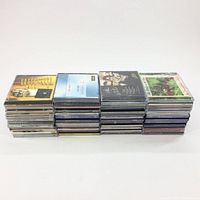 Front view of four stacks of various CD jewel cases showing cover art, approximately 45 CDs total.