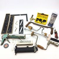 Full assortment of handyman tools including caulking gun, hand drill, parallel rules, bore cutters, nail cartridge and others
