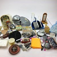 Wide view of the household lot including child's iron, brushes, shoe polish tins, shoe horns, broom, and other assorted items