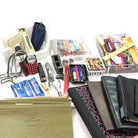 Full overview of assorted office supplies showing folders, folios, calculators, staplers, writing tools, glue bottles, rulers, and desk storage baskets