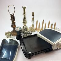 Photo showing all items together: electric griddle with plates and controller, five lamp bases of various styles and conditions, wooden rack, and plastic water containers.
