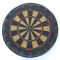 Front view of vintage dart board showing numbering, color segments and worn playing surface.