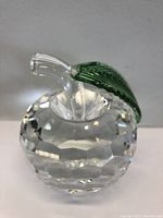 Front angle view of the crystal apple showing the clear faceted body and green crystal leaf with clear stem